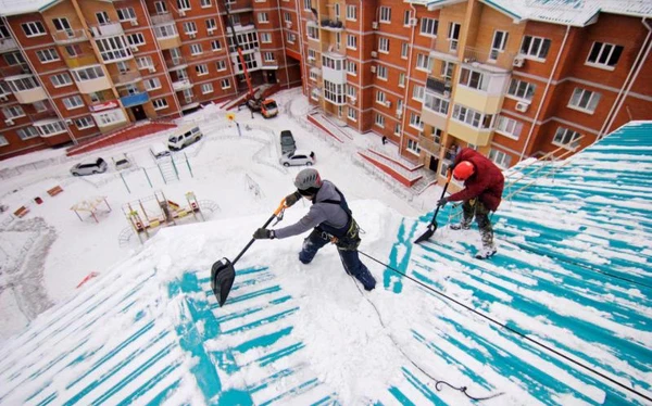 Фото Очистка снега с крыши здания